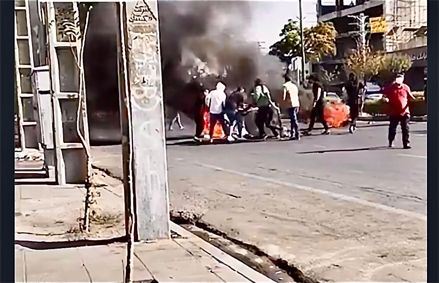 Young protesters setting up a barrier in a street in Karaj, near Tehran on October 12, 2022