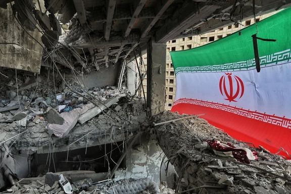Rubble is seen inside a heavily damaged building in Tabriz with an Iranian flag hanging from the structure after an airstrike during the Iran war, March 23, 2026