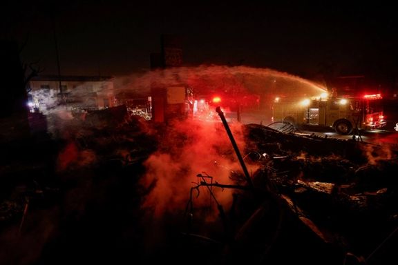 Firefighters hose down a hotspot at a commercial building that burned down during the Eaton Fire, in Altadena, California, US, January 10, 2025.