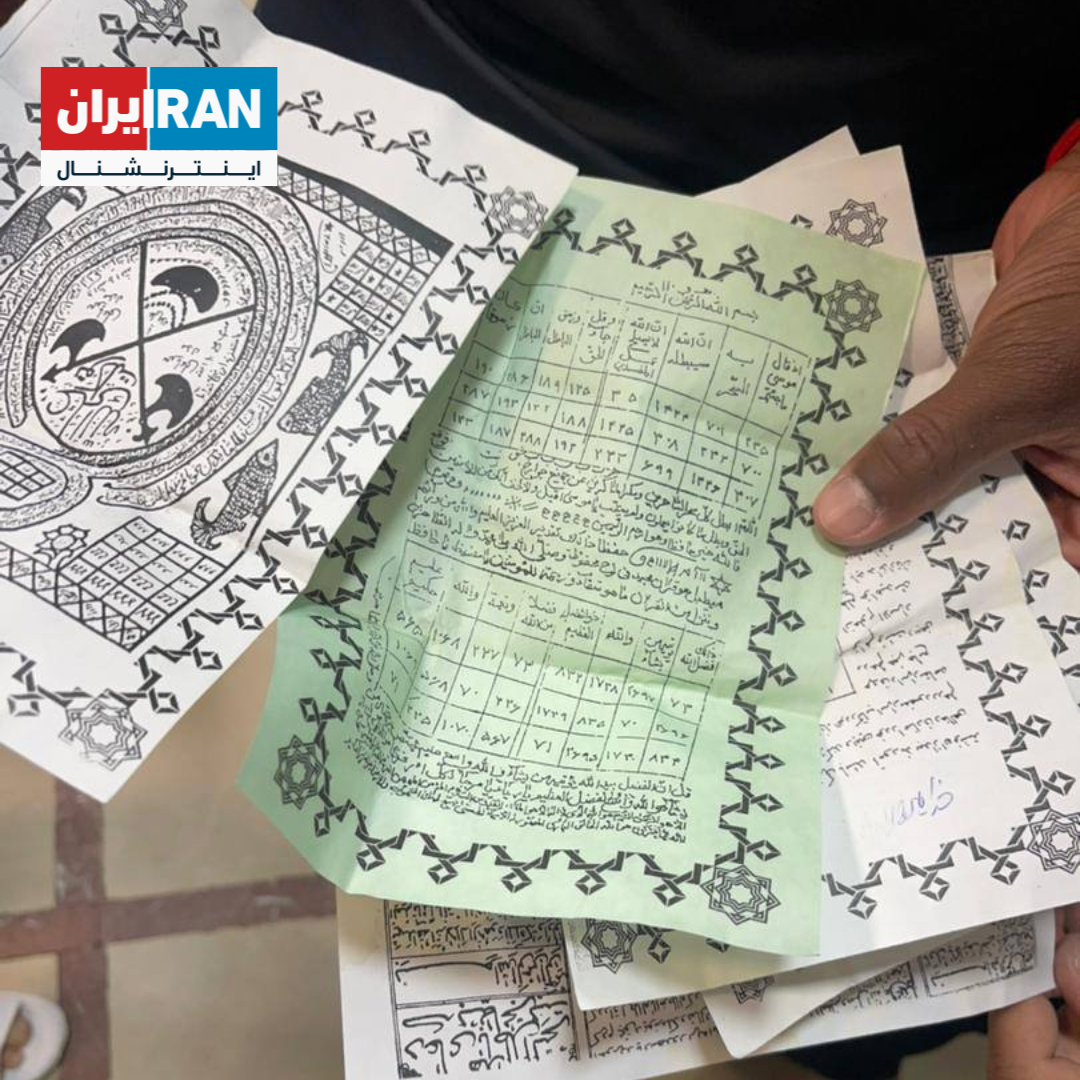 a person is holding a piece of paper with arabic writing on it