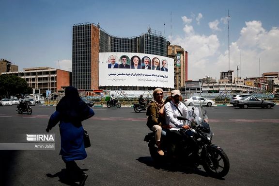 A giant electoral banner featuring portraits of Iran's early presidential elections candidates that is hanging on a governmental building in downtown Tehran (June 2024)