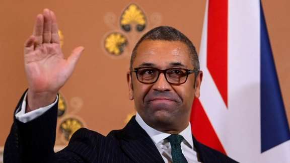 British Foreign Secretary James Cleverly gestures as he speaks to members of the press in London, December 12, 2022