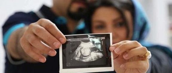 As Iranian couple holding an ultrasound picture of their baby