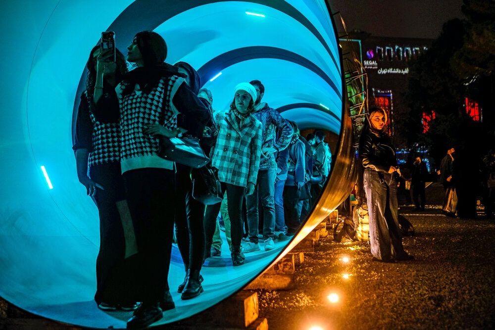 Visitors walk through a tunnel-shaped installation exhibited at the Tehran Design Week, November 15, 2025