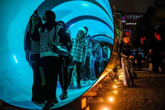 Visitors walk through a tunnel-shaped installation exhibited at the Tehran Design Week, November 15, 2025
