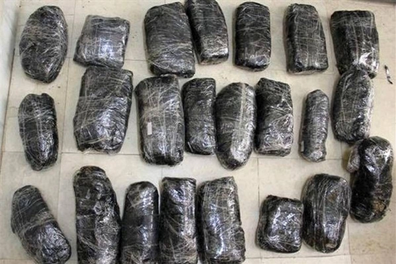 Bundles of opium wrapped in black plastic and tape, likely seized during a drug enforcement operation in Iran. (Undated)