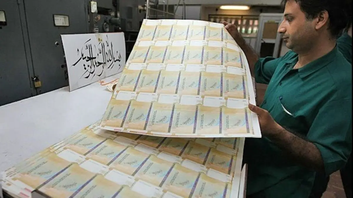A worker inspects freshly printed Iranian banknotes