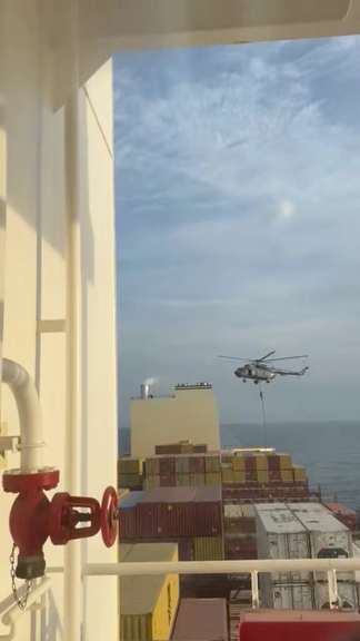 An official slides down a rope during a helicopter raid on MSC Aries ship at sea in this screen grab obtained from a social media video released on April 13, 2024. Video obtained by Reuters/via REUTERS/File Photo