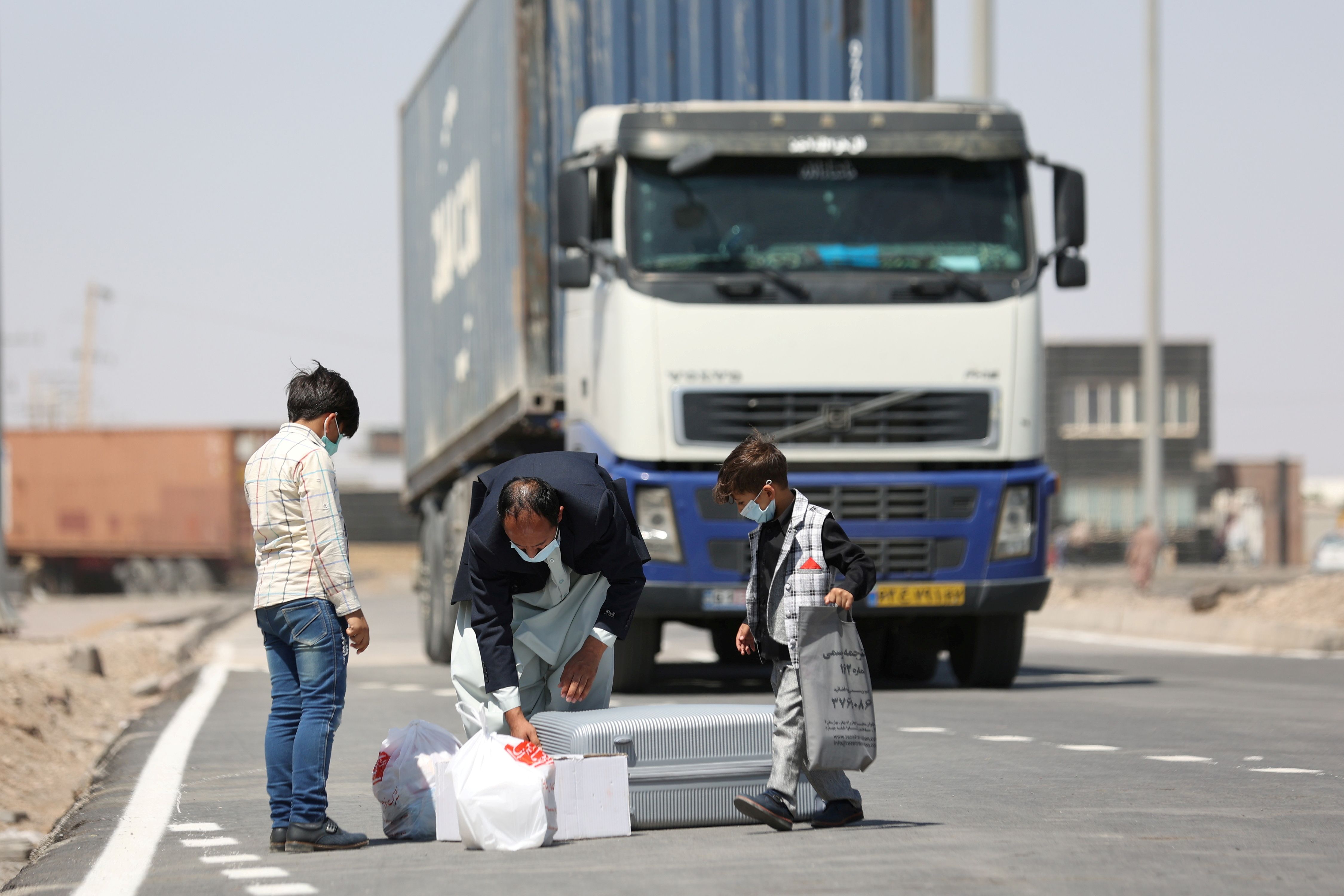 Afghan nationals stand at the Dowqarun border crossing between Iran and Afghanistan, Razavi Khorasan Province, Iran August 29, 2021.