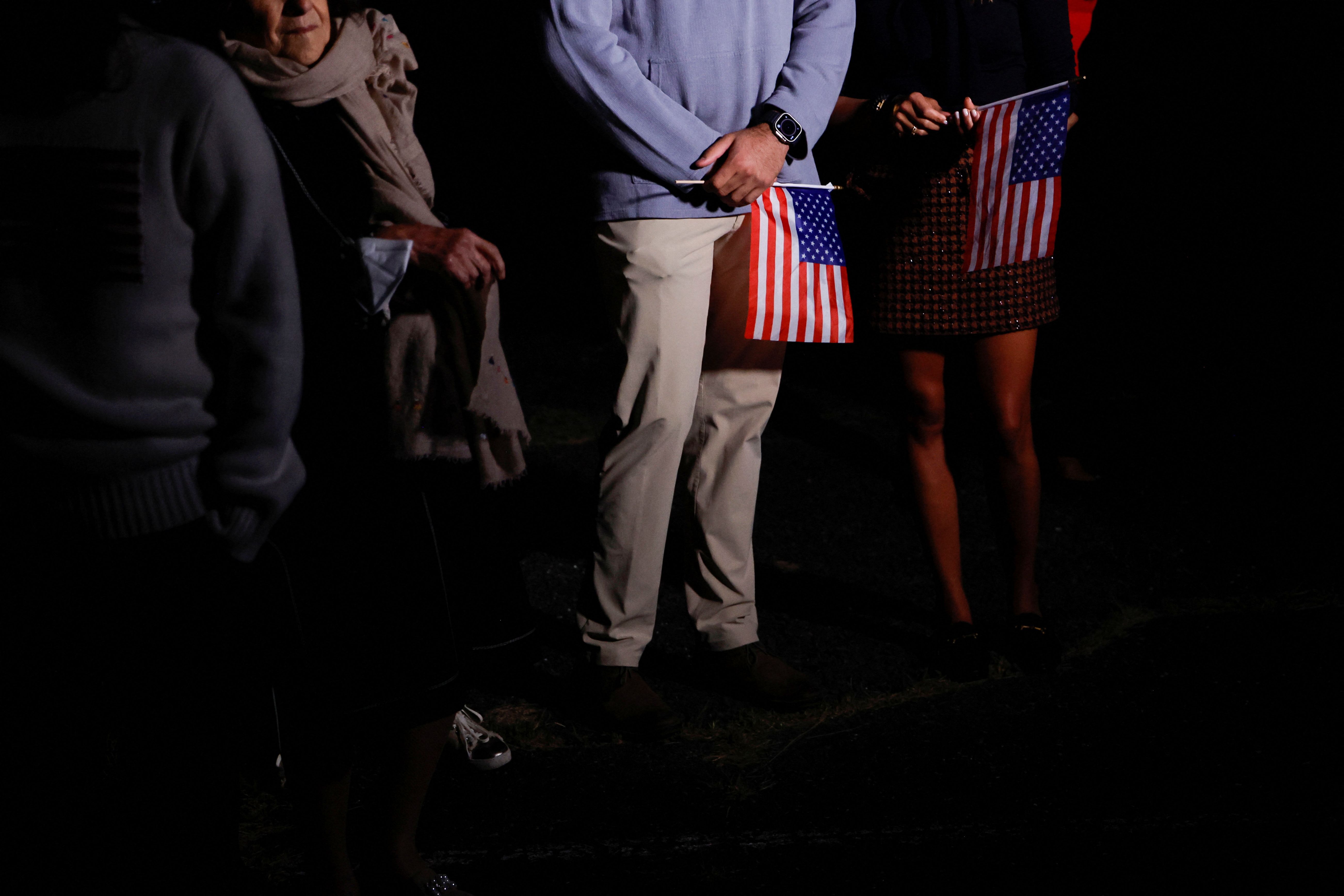 Family members with US flags wait to greet freed American detainees at Davison Army Airfield at Fort Belvoir, Virginia, September 19, 2023.  