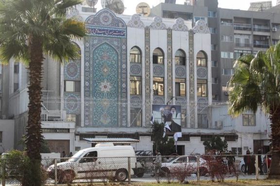Rebel fighters stand near the Iranian embassy with a torn poster of Hezbollah leaderHassan Nasrallah and late Iran's Revolutionary Guards' top commander Qassem Soleimani after Syrian rebels announced that they have ousted President Bashar al-Assad, in Damascus, Syria December 8, 2024.