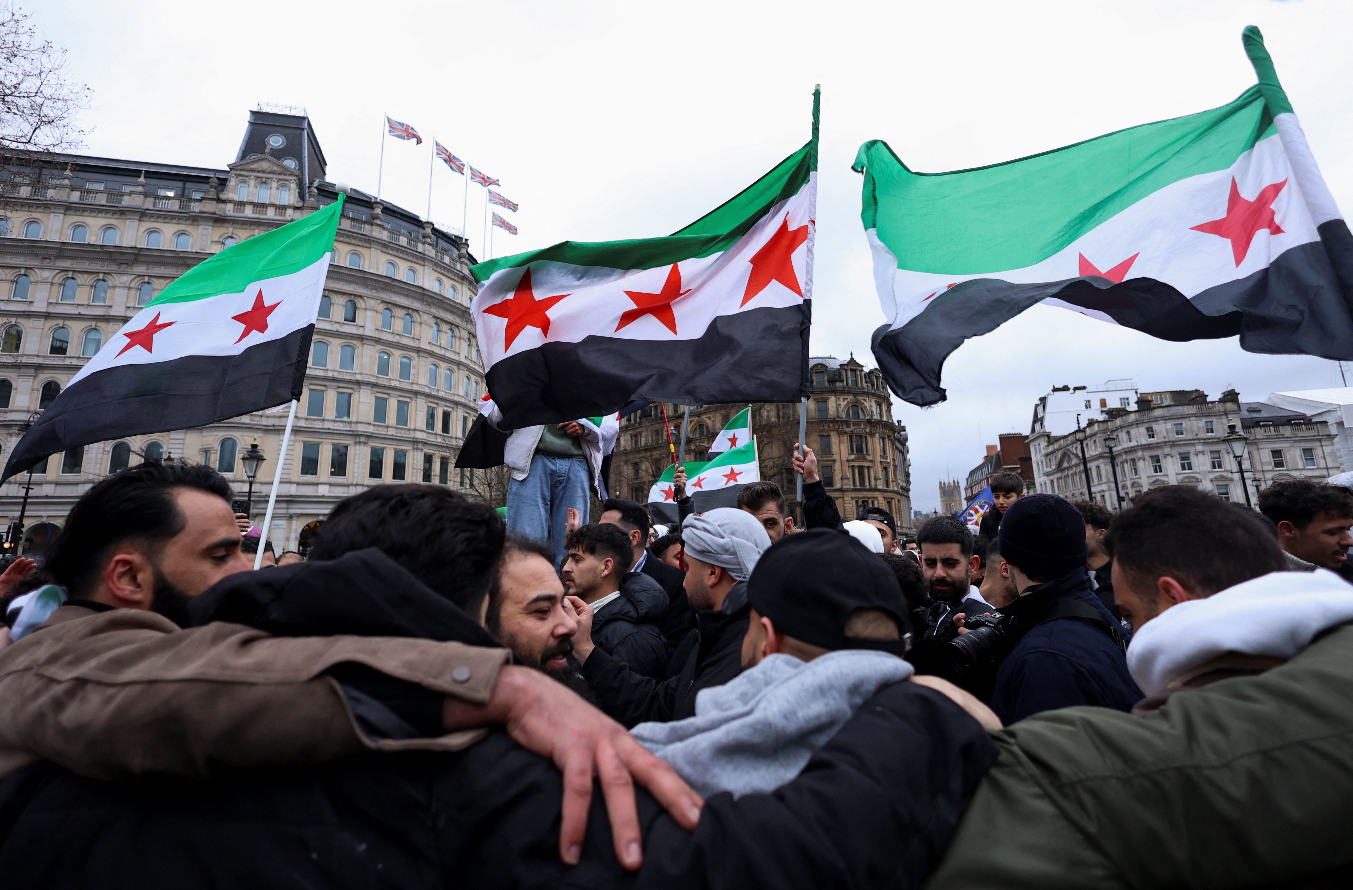 People wave Syrian opposition flags as they gather in Trafalgar Square, after Syrian rebels announced that they have ousted Syria's Bashar al-Assad, in London, Britain December 8, 2024.