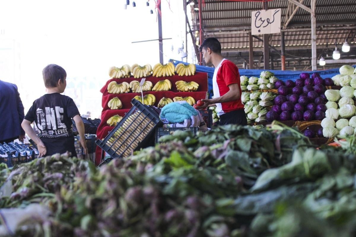 A man looks at fresh produce in a fruit and vegetable market in Tehran, Iran, March 2025