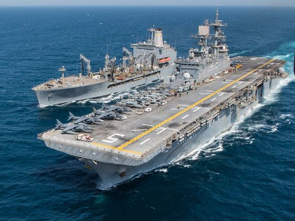 Handout photo dated July 28, 2014 shows the amphibious assault ship USS Bataan (LHD 5), right, and the fleet replenishment oiler USNS Laramie (T-AO 203) conduct a replenishment-at-sea in the Arabian Sea.