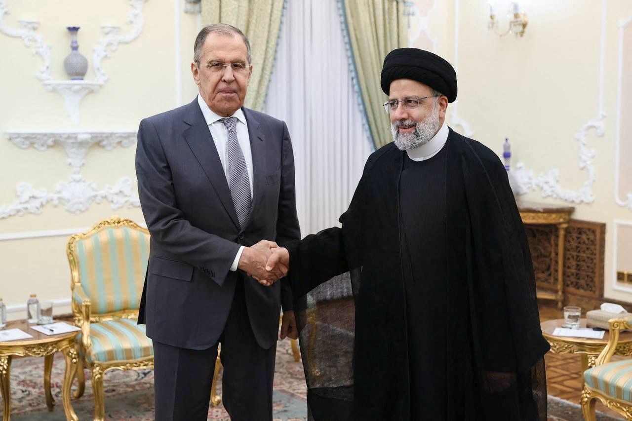Russian Foreign Minister Sergei Lavrov shakes hands with Iranian President Ebrahim Raisi during a meeting in Tehran, Iran October 23, 2023.
