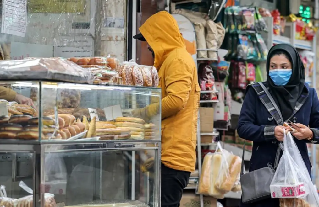 File photo of a a woman shopping at a bakery in Tehran, Iran, amid rising food prices and persistent inflation.