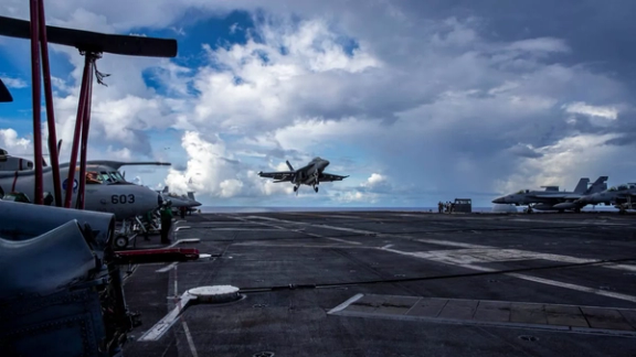 یک هواپیمای سوپر هورنت F/A-18F متعلق به اسکادران ضربتی VFA-41 در حال فرود با قلاب روی عرشه ناو هواپیمابر یواساس آبراهام لینکلن در اقیانوس آرام است.