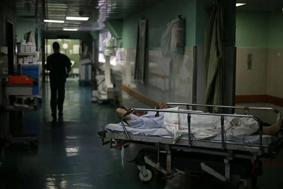 A patient lies on a stretcher in a dark hospital corridor during a power cut in Iran.