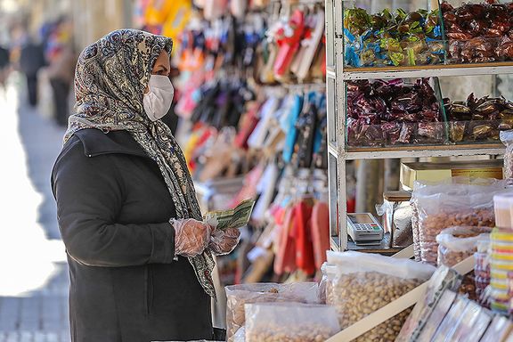 A woman shopping in Tehran with Iranian currency in hand