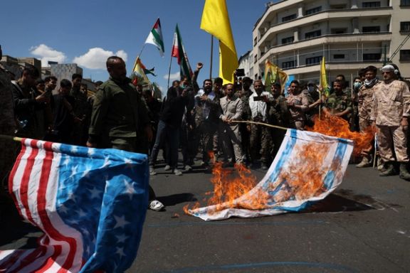 Iranians burn Israeli and US flags during a rally marking the annual Quds Day, in Tehran, April 14, 2023