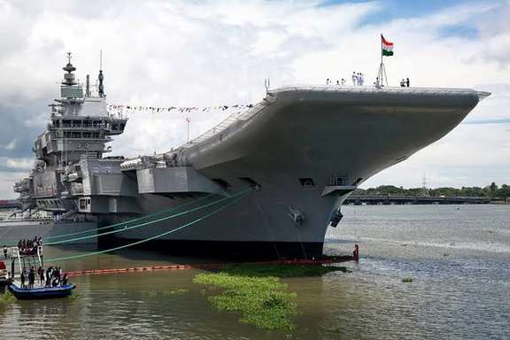 Indian Navy officers stand on the flight deck of India's aircraft carrier INS Vikrant at a shipyard in Kochi, September 2022.