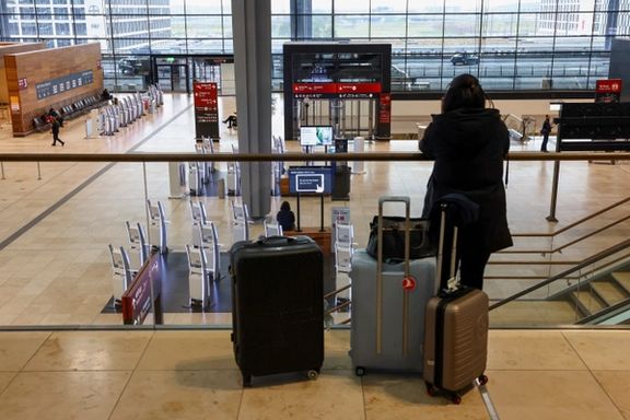 A person with luggage stands in an airport hall, as airport workers protest at BER airport during a strike called by German trade union Verdi, in Berlin, Germany, March 13, 2023.