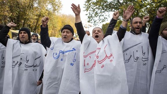 Pro-establishment protesters in Iran wearing shrouds with Khamenei's name printed on them