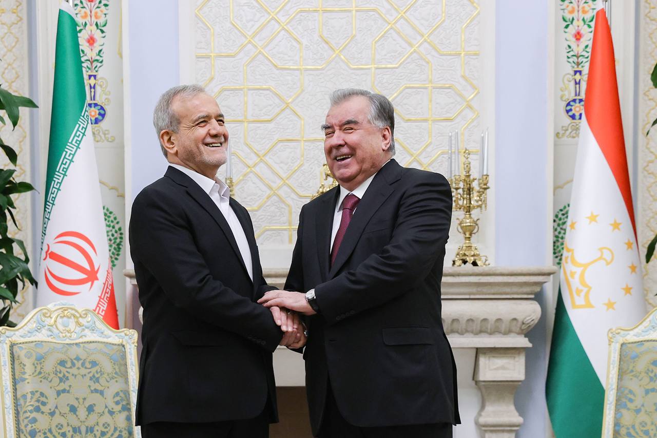 Iranian President Masoud Pezeshkian and Tajik President Emomali Rahmon shake hands