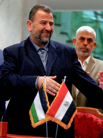 Head of Hamas delegation Saleh al-Arouri, with Gaza's Hamas leader Yahya Sinwar behind him, signs a reconciliation deal with Fatah leader Azzam Ahmad (not pictured), in Cairo, Egypt, October 12, 2017.