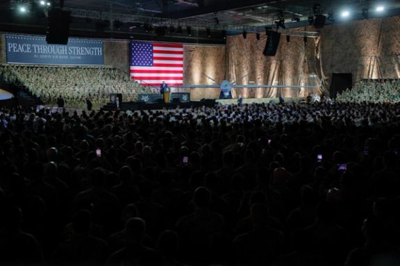 US President Donald Trump delivers remarks to U.S. troops, next to a banner reading, "Peace Through Strength", during a visit to Al Udeid Air Base in Doha, Qatar, May 15, 2025.