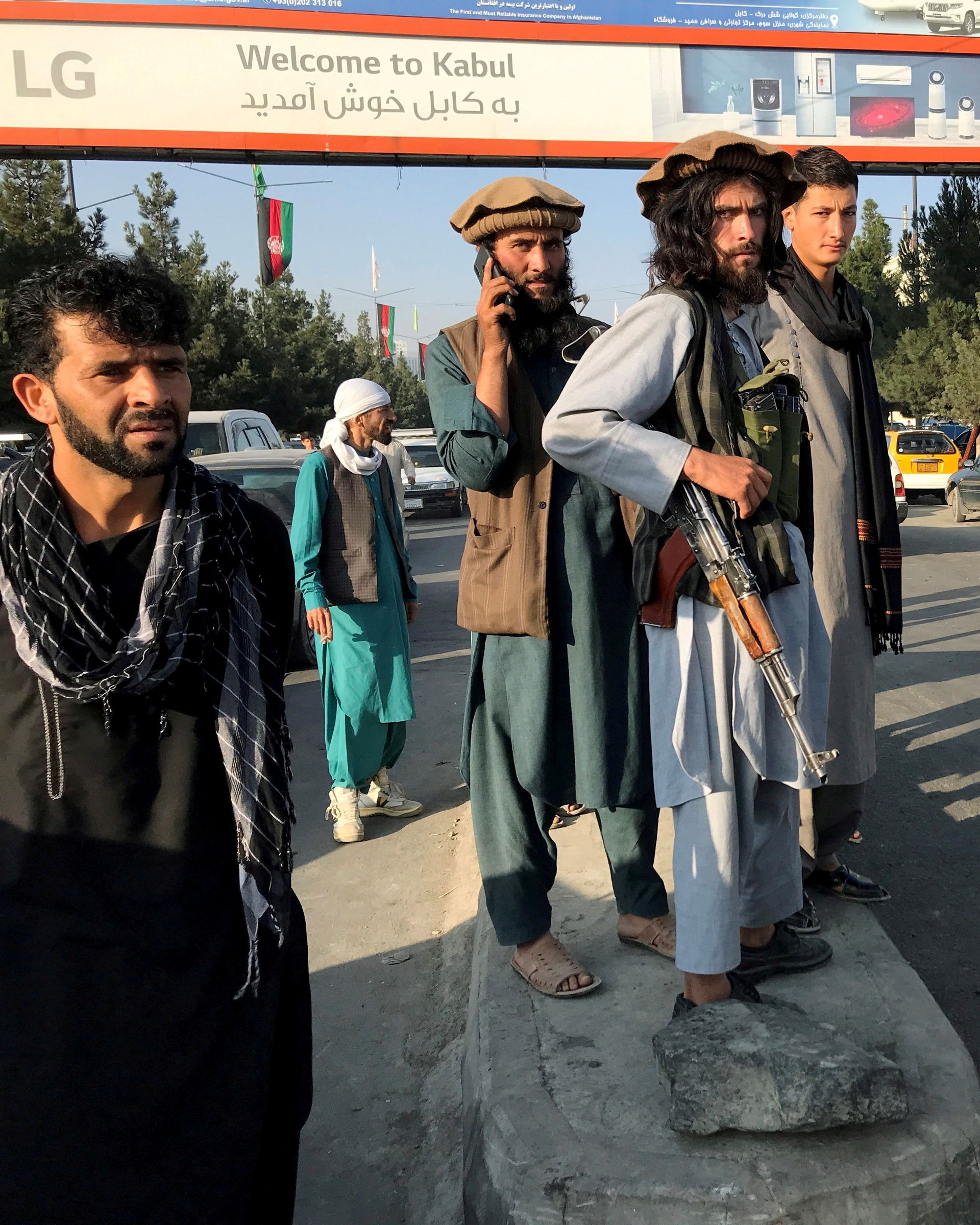A member of Taliban (center) stands outside Hamid Karzai International Airport in Kabul, Afghanistan, August 16, 2021. 