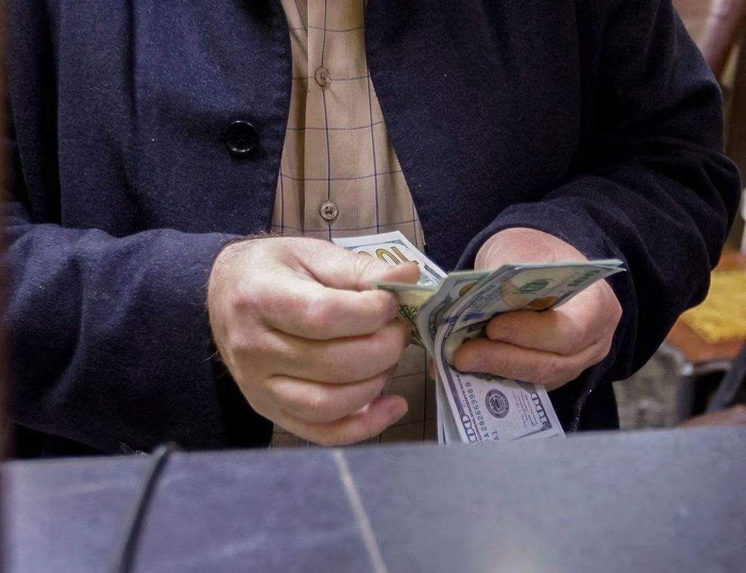A man counts US dollars at a currency exchange shop in Baghdad, Iraq, January 23, 2023.