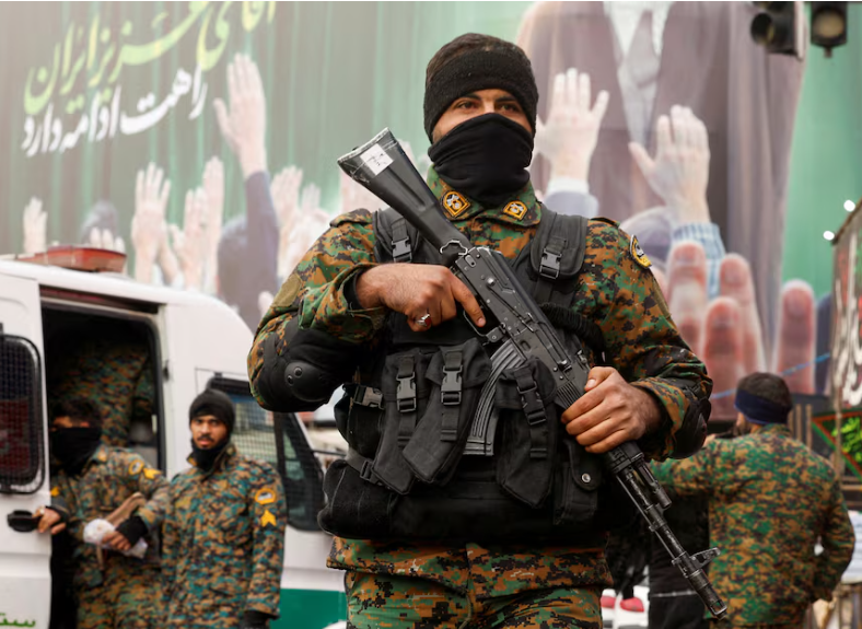Members of the police stand guard on a street, with a large billboard featuring Iran's late Supreme Leader Ayatollah Ali Khamenei in the background, amid the U.S.-Israeli conflict with Iran, in Tehran, Iran, March 12, 2026. REUTERS/Alaa Al-Marjani Purchase Licensing Rights