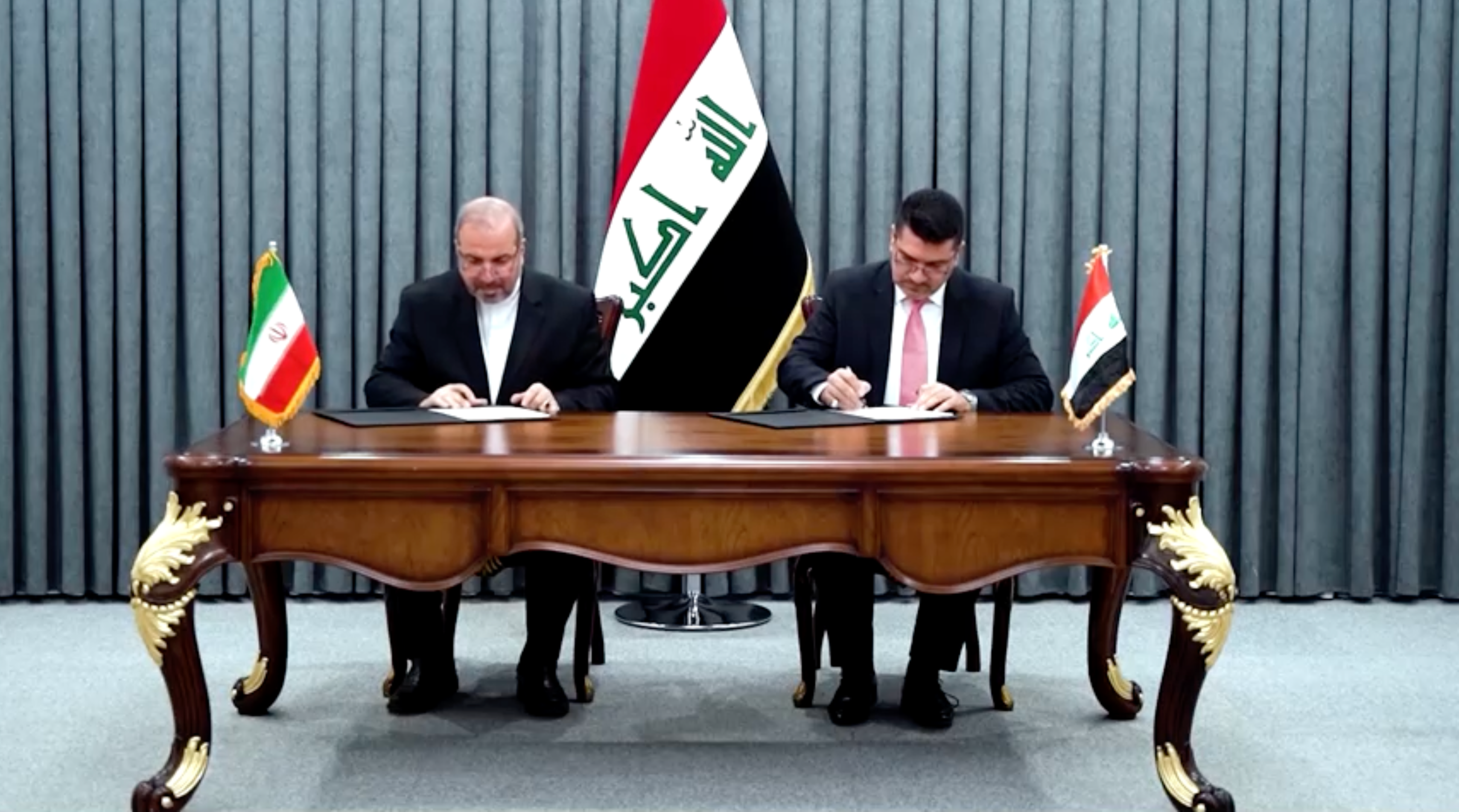 Iraqi Prime Minister Mohammed Shia Al-sudani (right) and Iran’s ambassador Mohammad-Kazem Ale-Sadegh during the signing ceremony of the barter deal on July 11, 2023 