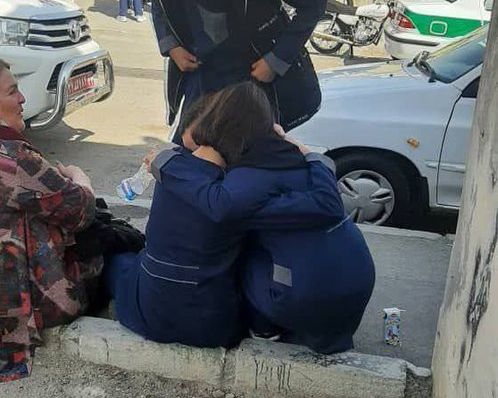 Two schoolgirls hugging each other after a poisonous gas attack at their school