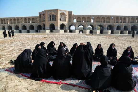 Families of protesting farmers sit on the dry bed of the Zayandeh Rud River in Iran’s Isfahan during a protest gathering in November 2021.