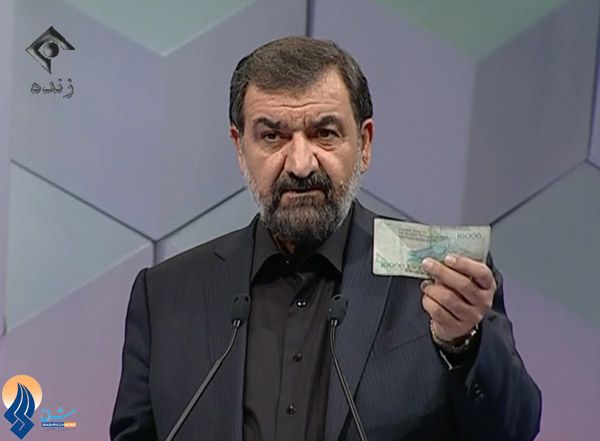 Mohsen Rezaei holds a banknote during a televised debate in Iran.