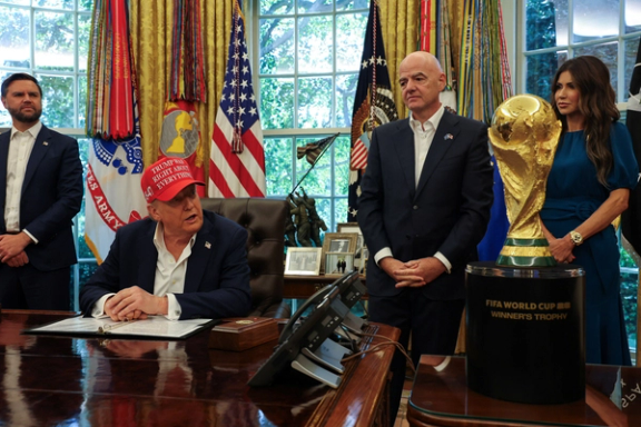 US President Donald Trump makes an announcement, while US Vice President JD Vance looks on, as FIFA president Gianni Infantino stand behind the FIFA World Cup Trophy, in the Oval Office at the White House in Washington, DC, US, August 22, 2025.