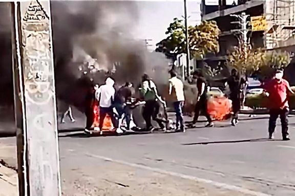 Protesters setting fire to trash bins in a street in October