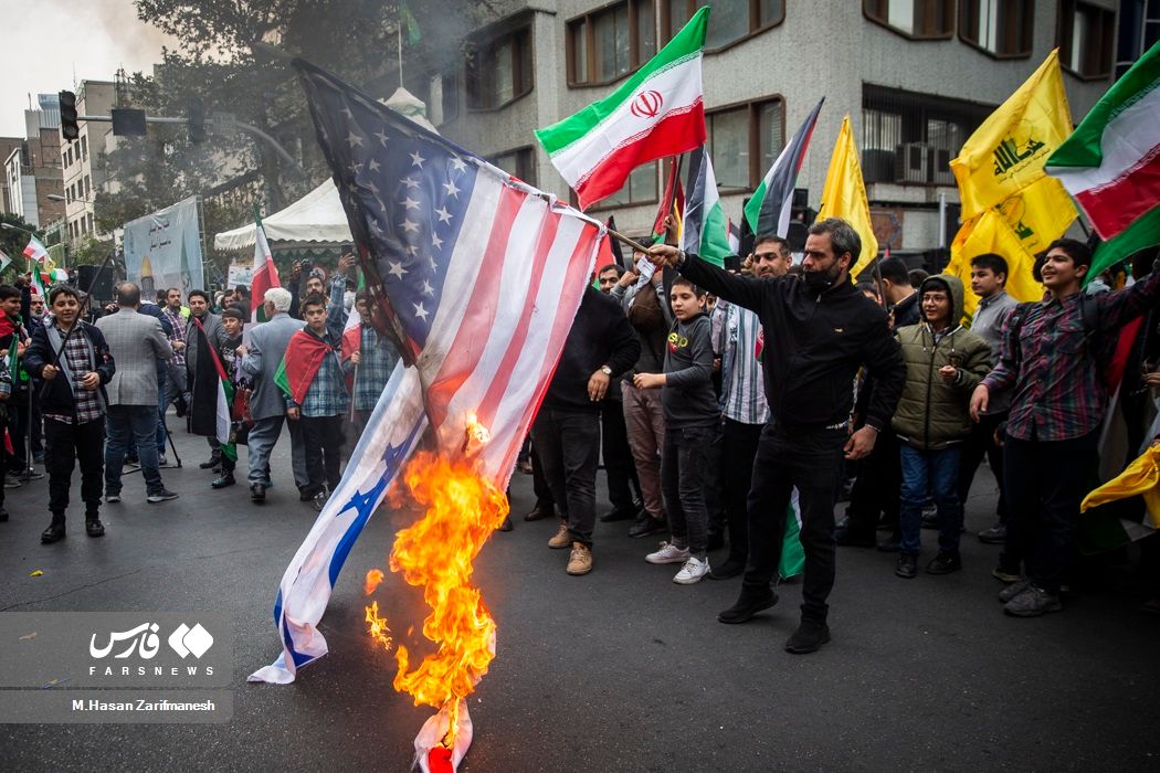 People burning flags of the US and Israel during a regime-sponsored rally in Tehran on November 4, 2023 
