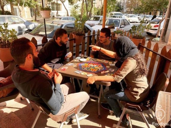Iranian youths playing a boardgame at a café