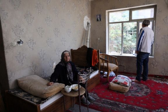 A woman sits inside her damaged house at an impact site following the Israeli strikes on Iran, in Tehran, Iran, June 14, 2025.