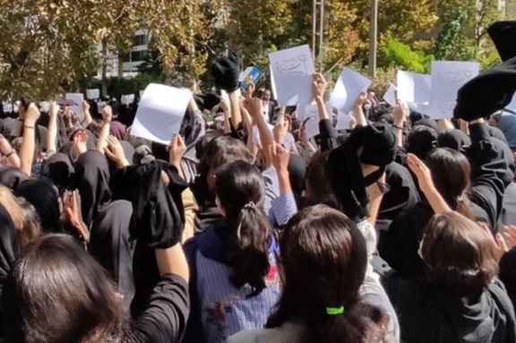 A group of university students unveiling in protest to mandatory hijab