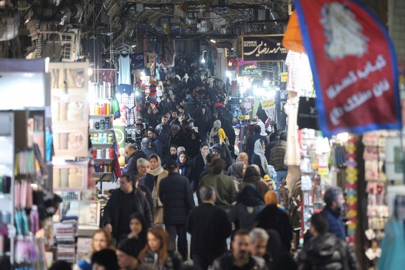 Shoppers walk through a crowded bazaar in Iran.