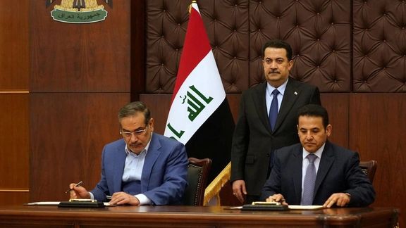 Iraqi Prime Minister Mohammed Shia al-Sudani looks on as Iraq's National Security Adviser Qasim al-Araji and Iran's former Supreme National Security Council secretary Ali Shamkhani sign a security agreement in Baghdad, March 19, 2023.