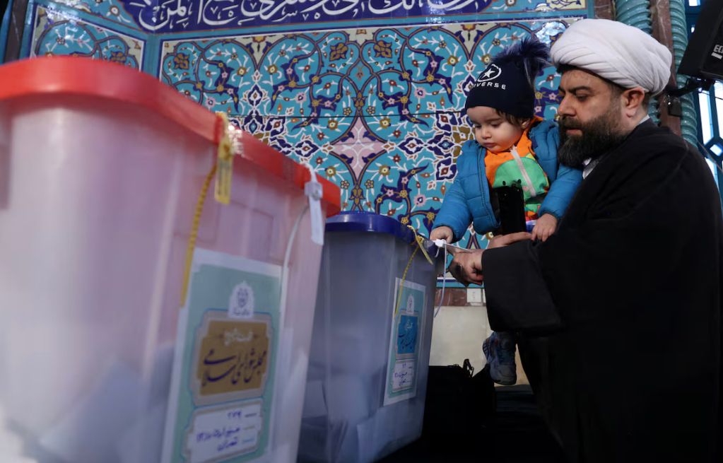 An Iranian cleric casts his vote during parliamentary elections at a polling station in Tehran, Iran, March 1, 2024.