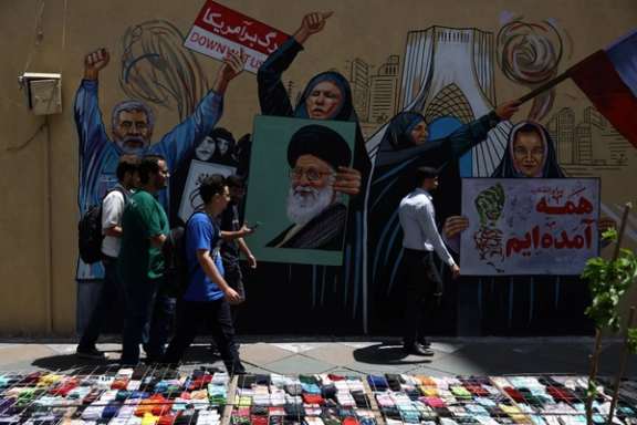 People walk on a street near a mural featuring an image of the late Supreme Leader Ali Khamenei, in Tehran, Iran, May 6, 2026.