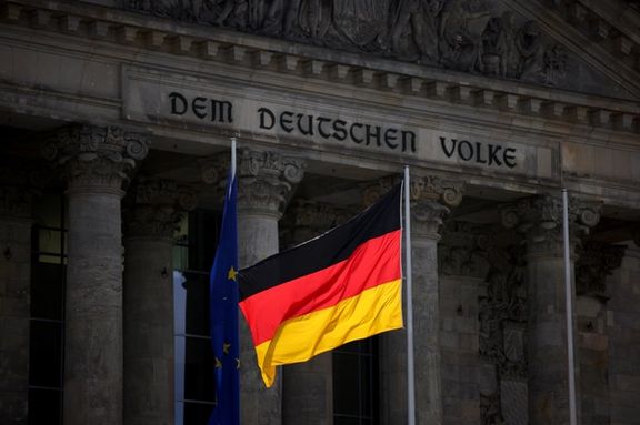 The German national flag flies in front of the Reichstag building, the seat of the lower house of the parliament Bundestag, in Berlin, Germany.