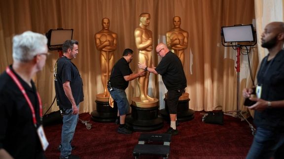 Workers adjust an Oscar themed decoration as preparations for the 98th annual Academy Awards ceremony get underway in Los Angeles, California, US, March 14, 2026.