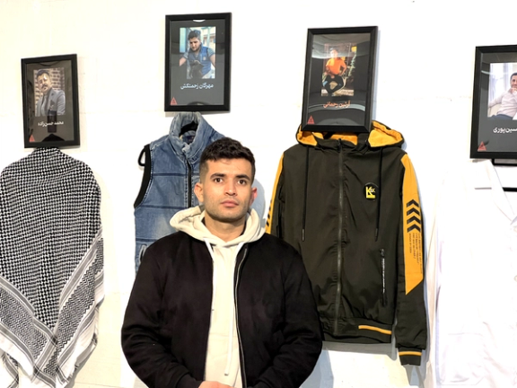 Slain teen protestor, Artin Rahmani's uncle standing next to Artin's jacket